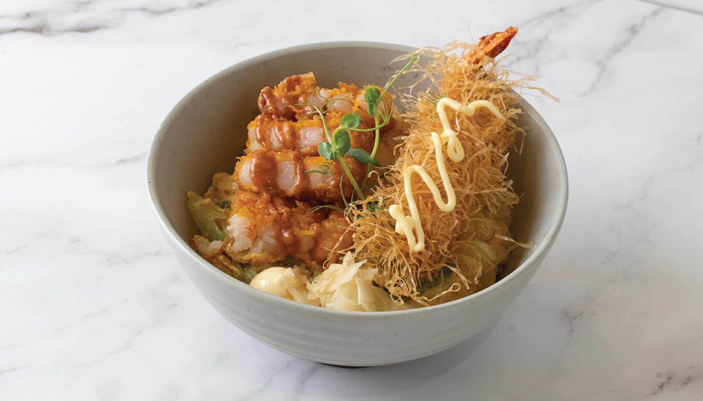 A loaded donburi bowl with a large fried prawn and mayonnaise