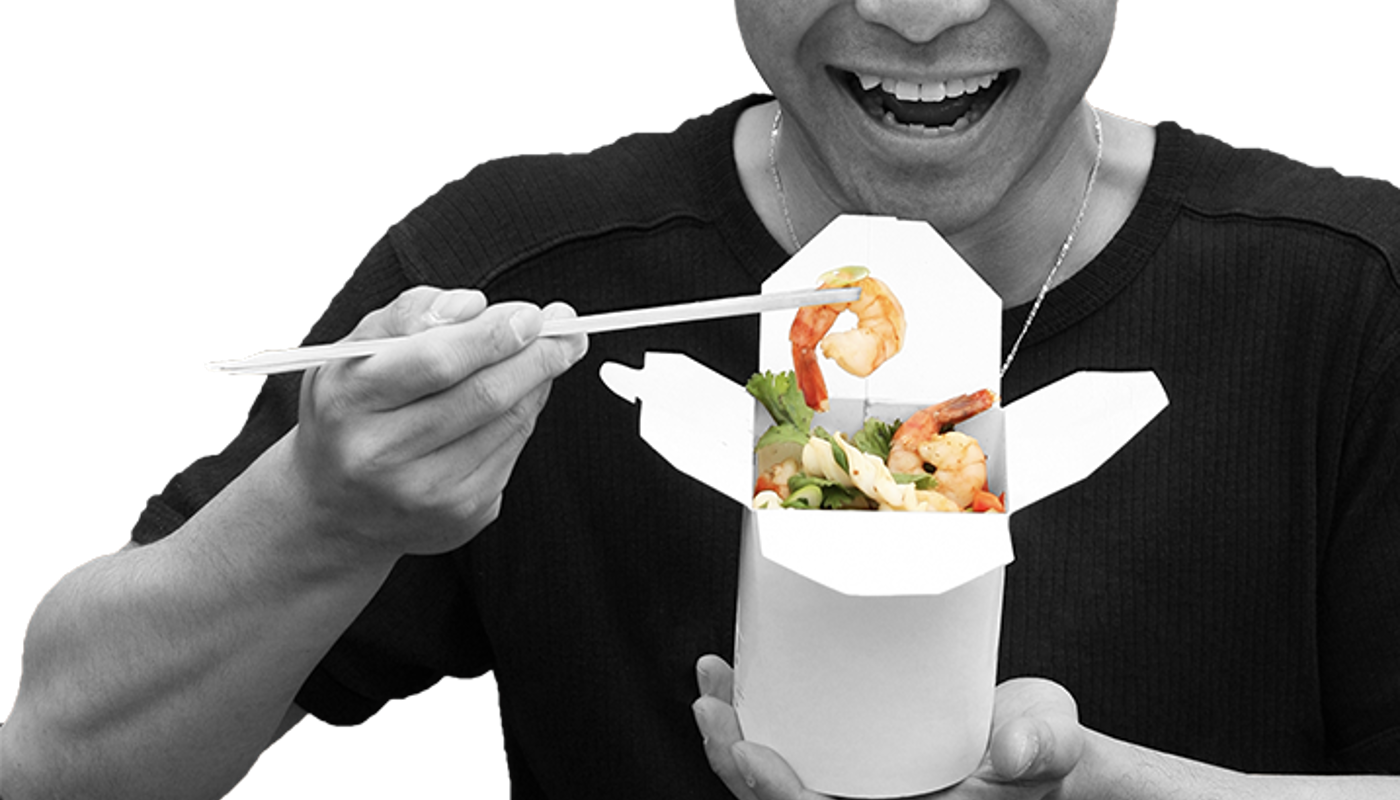 Wok n Noodle founder Lee eating a prawn from a serving box