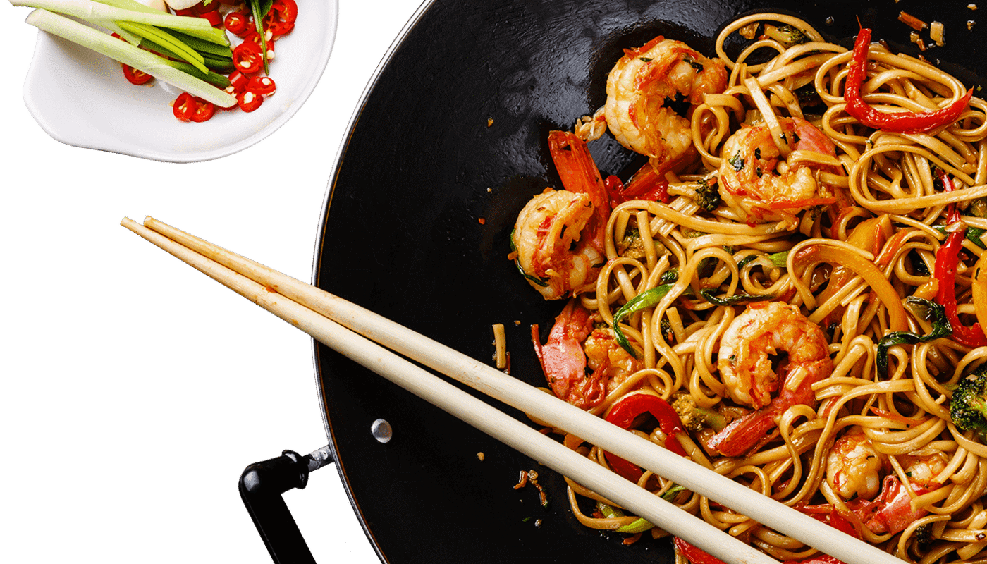 Large wok with sauced noodles and chopsticks