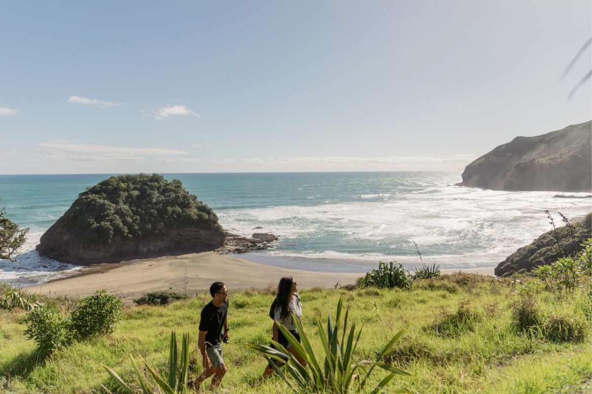 Couple out for a walk in Auckland's western beach coast.