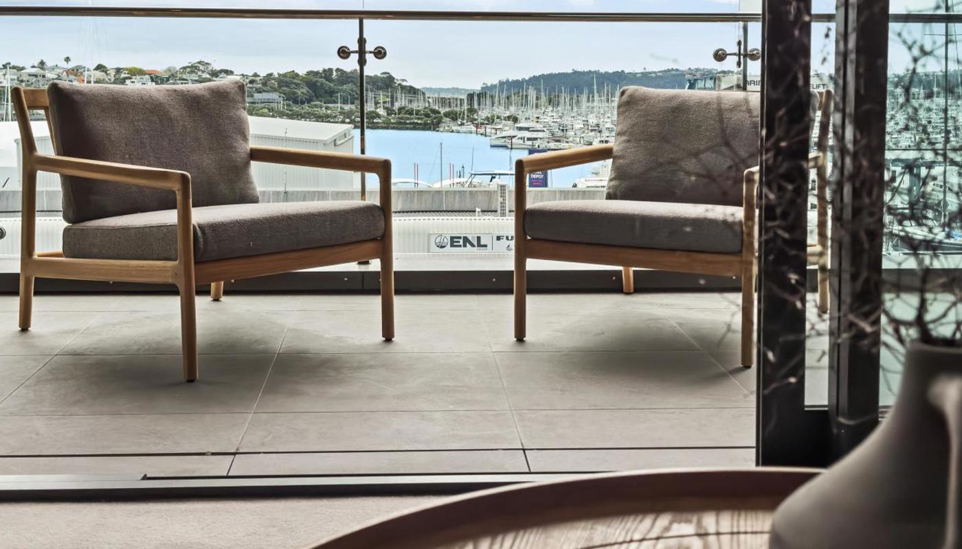 Seating area on the covered balcony looking out to the water.