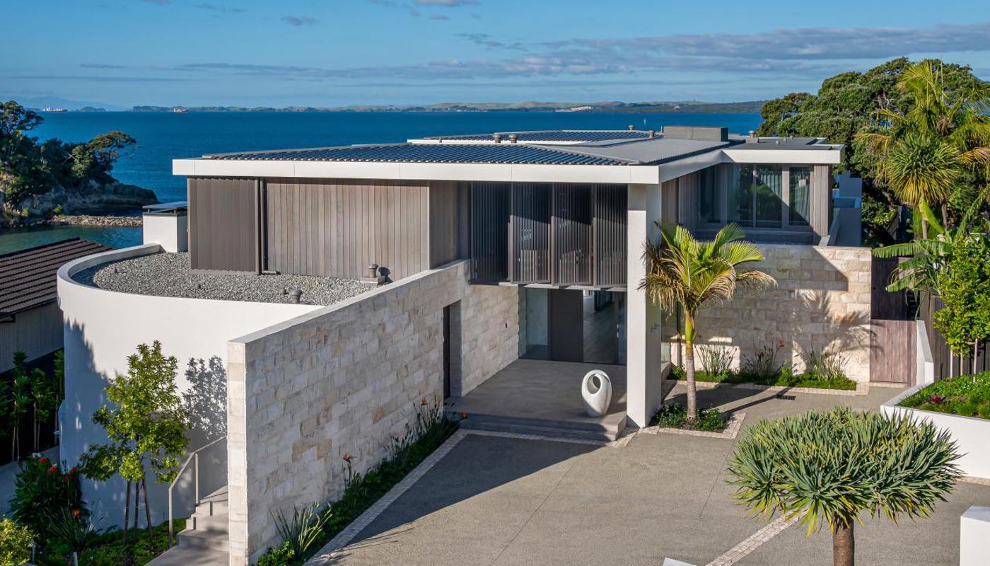 Exterior of property with the Hauraki Gulf in the background.