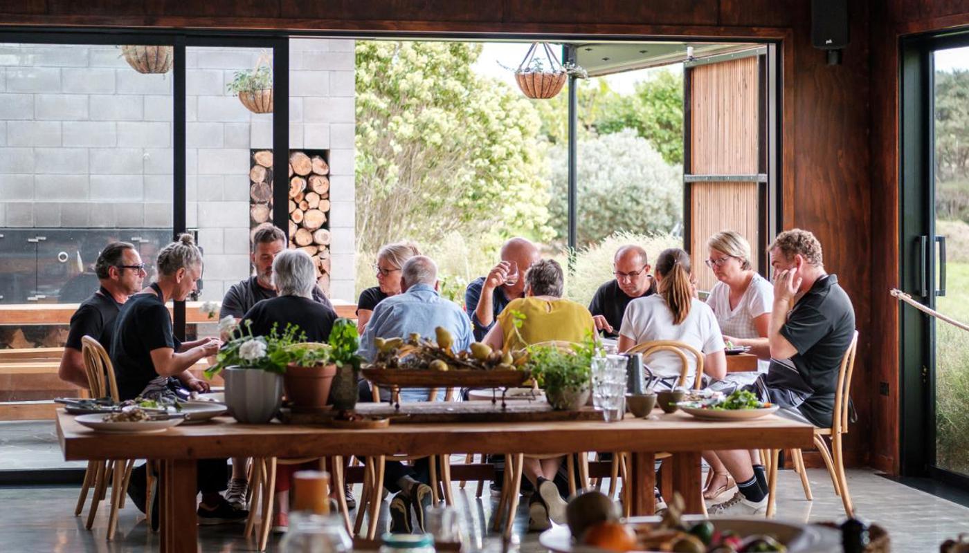 Guests sitting down to enjoy their lunch after a day spent preparing in the gardens and kitchen