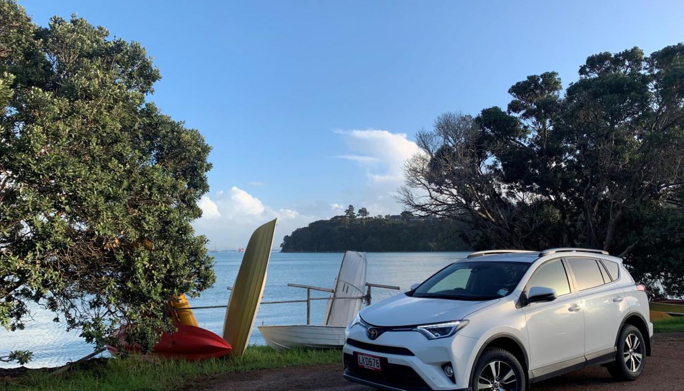 GO Rentals vehicle parked up beside beach landscape.